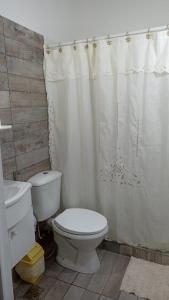 a bathroom with a toilet and a shower curtain at Ona Apart por Día - Departamentos con cochera in Corrientes
