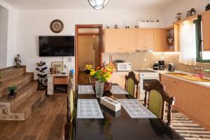 a kitchen with a table with chairs and a counter top at Villa Roxani in Mesklá