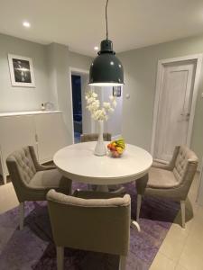 a dining room with a white table and chairs at Apartman Teatar in Sombor +11 photos