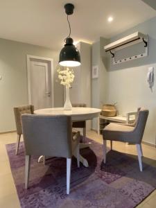 a dining room table with chairs and a vase of flowers at Apartman Teatar in Sombor