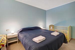 a bedroom with a bed with two towels on it at Casa chicken - mare, monti e bikers in Finale Ligure