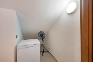 a small room with a refrigerator and a ceiling at Casa chicken - mare, monti e bikers in Finale Ligure