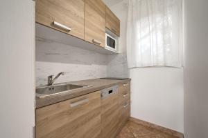 a kitchen with wooden cabinets and a sink at Holiday Park Mandrice in Mandre
