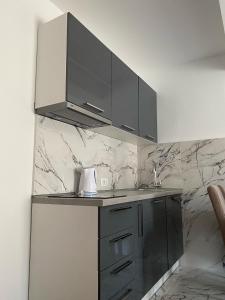 a kitchen with black cabinets and a counter top at Venera Apartments in Budva