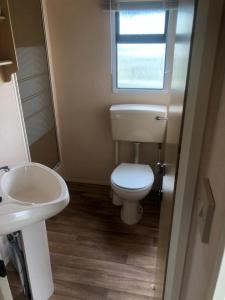 a small bathroom with a toilet and a sink at A4 THE CHASE 6 Berth Pet Friendly Caravan With Decking in Ingoldmells