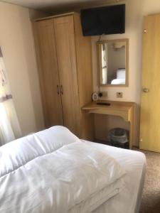 a bedroom with a bed and a desk and a mirror at A4 THE CHASE 6 Berth Pet Friendly Caravan With Decking in Ingoldmells +2 photos