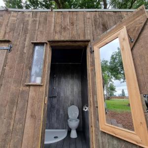 Willow Grove Farm Glamping في Lakenheath: حمام مع مرحاض داخل مبنى