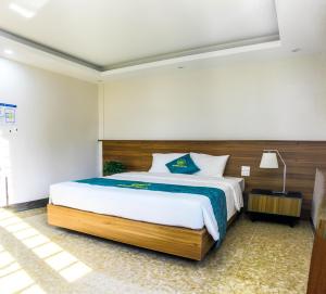 a bedroom with a large bed with a wooden headboard at Sunrise Motel in Ha Long