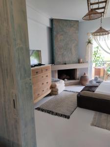 1 dormitorio con 1 cama y vestidor con TV en KD Boho Home, en Lávrion