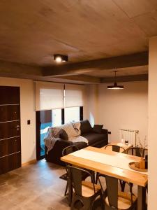 una sala de estar con una mesa y un sofá en AIKEN con cochera PB, en San Martín de los Andes