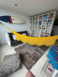 ein Wohnzimmer mit einem gelben Netz und einem Surfbrett in der Unterkunft São João Beach Lounge in Costa da Caparica