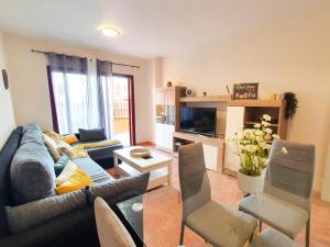 a living room with a couch and chairs at Allamanda Home in Caleta De Fuste