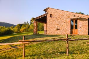蒙特普齐亚诺Agriturismo Il Serraglio的一块带木栅栏的石头建筑