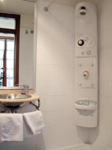 uma casa de banho com um lavatório e um espelho em La Plaza I em Luanco
