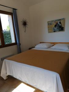 a bedroom with a large bed with a window at Gîte Les Romarins in Saint-Jean-de-Minervois