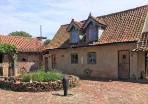 an old house with a brick yard in front at Farmhouse B&B in Saint-Georges