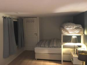 a small bedroom with a bed and a lamp at Senja, Skaland apartment in Skaland