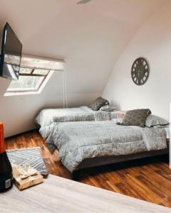 two beds in a room with a clock on the wall at Domos Dream in La Serena