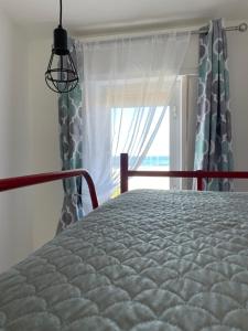 een slaapkamer met een bed en een raam bij Casa Vacanze Profumo di Mare in La Caletta