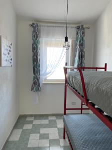 een slaapkamer met een stapelbed en een raam bij Casa Vacanze Profumo di Mare in La Caletta +15 foto's