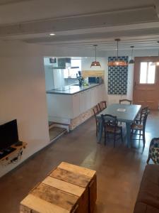 een keuken en een woonkamer met een tafel, een keuken en een eetkamer bij la maison des vendangeurs in Villesequelande