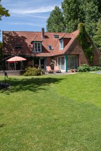 une maison en briques avec une pelouse devant elle dans l'établissement A la Maison du Héron, à Villeneuve d'Ascq