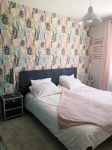 - une chambre avec un grand lit et du papier peint floral dans l'établissement VILLA VAI avec piscine, à Vaison-la-Romaine