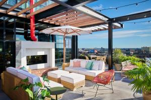 a patio with a couch and chairs and an umbrella at Virgin Hotels New Orleans in New Orleans