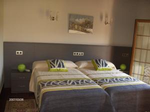two beds sitting next to each other in a bedroom at Hotel Rural Las Palmeras Muskiz in Muskiz