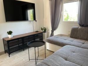 salon z kanapą, stołem i telewizorem w obiekcie Apartments Fortuna w Biogradzie na Moru
