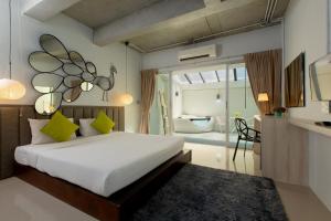 a bedroom with a large bed and a bathroom at The Nest Resort Patong in Patong Beach