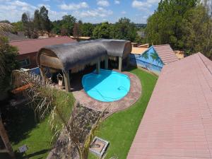 an overhead view of a house with a swimming pool and a roof at The Log Cabin Apartments Hotel in Standerton
