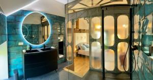 een badkamer met een wastafel en een spiegel bij Le Petit Caviste - Chambres D'hôtes & Suites in Castagnol
