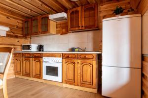 a kitchen with wooden cabinets and a white refrigerator at Widokowe tarasy in Chwaszczyno