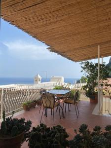 a patio with a table and chairs and the ocean at Casa Positamo in Positano