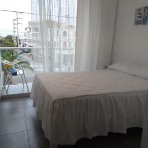 1 dormitorio con cama y ventana grande en Coco Lodge Paracas, en Paracas