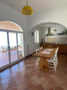 a dining room with a table and a kitchen with a patio at Casa Positamo in Positano