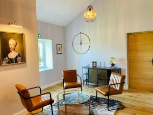 een woonkamer met stoelen en een glazen tafel bij Le Petit Caviste - Chambres D'hôtes & Suites in Castagnol