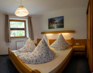 ein Schlafzimmer mit einem Bett mit Kissen darauf in der Unterkunft BergQuell in Tannheim