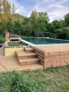 uma piscina com um deque de madeira ao lado de uma piscina em Mas Paradiso em Allemagne-en-Provence