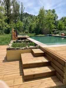 einen Pool mit Stufen neben einer Holzterrasse in der Unterkunft Mas Paradiso in Allemagne-en-Provence