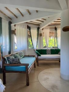 a living room with two couches and two windows at Miky House in Watamu