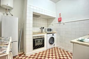 una cocina con lavadora y lavadora en Portas da Sé Apartments, en Lisboa
