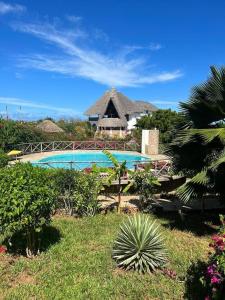 a resort with a swimming pool and a building at Miky House in Watamu