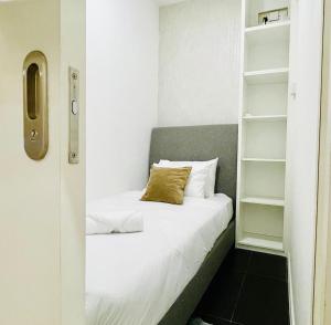 een kleine slaapkamer met een bed en planken bij Arcoris Mont Kiara 1 to 5 pax Designer Netflix Chill Balcony in Kuala Lumpur