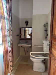 a bathroom with a toilet and a sink at Miky House in Watamu