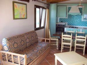 a living room with a couch and a table and a kitchen at 2 bedrooms appartement with sea view enclosed garden and wifi at Sassari in Sassari