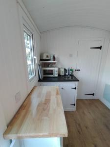 a kitchen with a wooden table in a room at Lavender hut in Brackloch