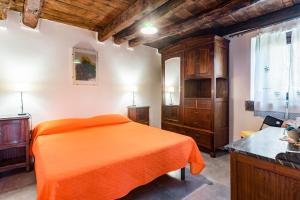 1 dormitorio con 1 cama de color naranja y armarios de madera en Nearby 5Terre Authentic Apartment, en Carrodano Inferiore