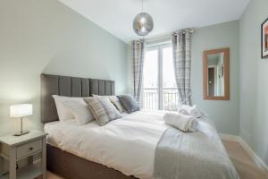 a bedroom with a large white bed with a window at The Argyle Apartment - Luxury - Parking in St Andrews
